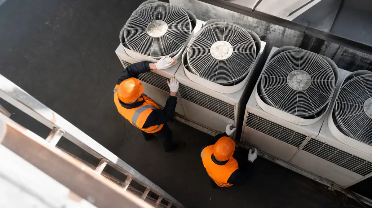 Overhead view of two workers servicing a bank of rooftop condensing units